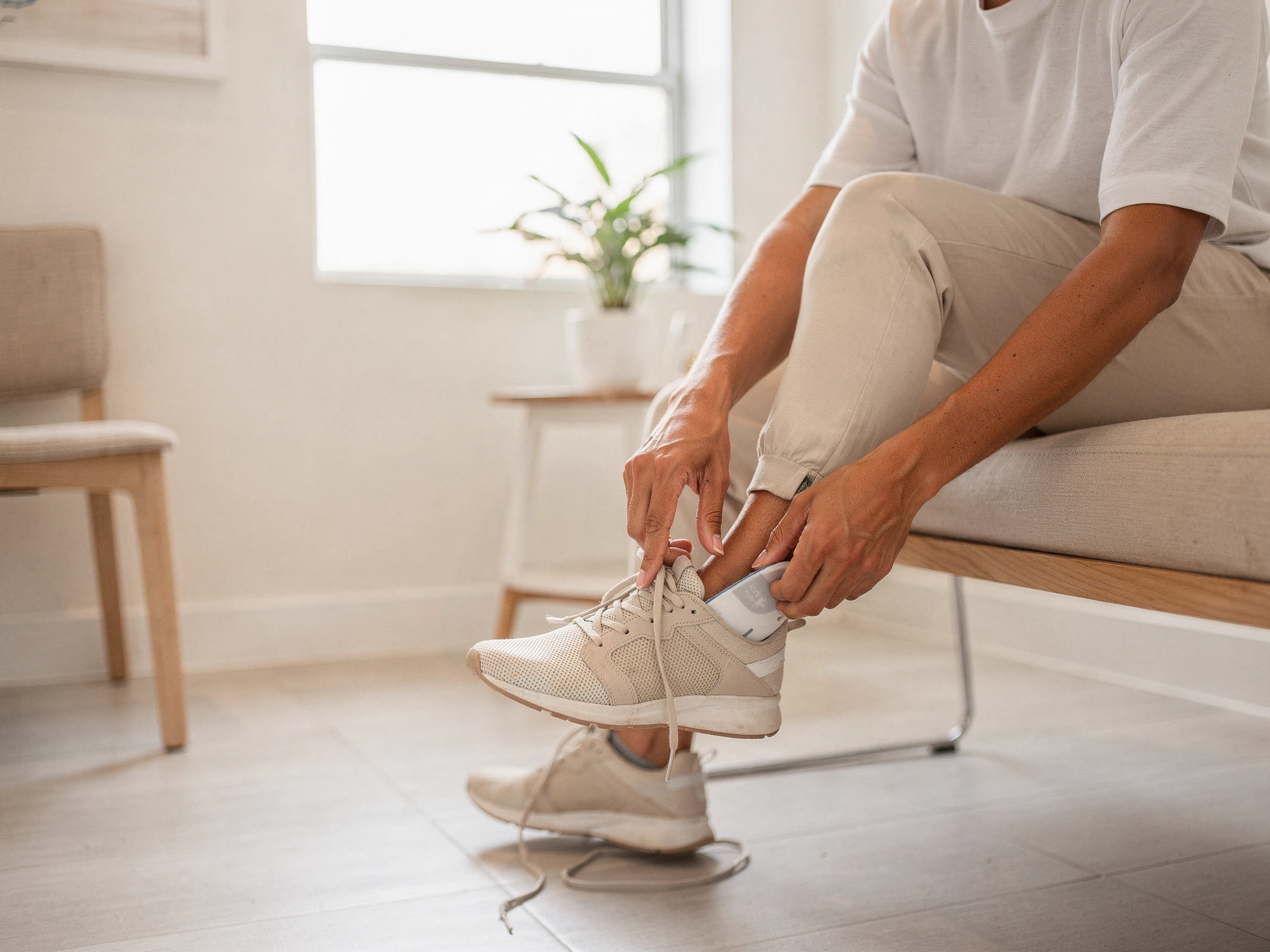 Man sitting on couch holding his foot, experiencing foot pain or bunion discomfort